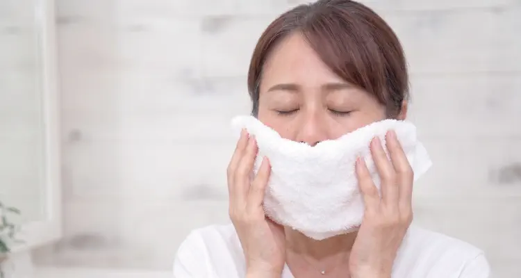 女性がタオルで顔を冷やしている様子